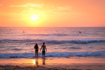 Fototapeta premium Couple at the beach at sunrise