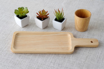 Empty wooden tray and small tree pots on sack tablecloth backgro