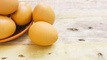 Eggs on the plate on a wooden table.