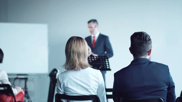 Attentive diverse multiracial young audience in a business meeting sitting on chairs listening to a presentation from a manager or team leader