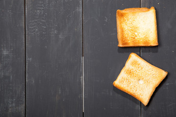 Toast the bread on a black wooden background
