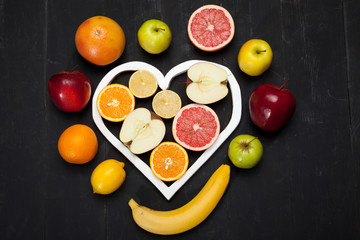 Fruits and heart on black background