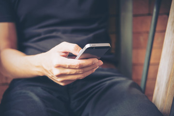 A man using smart phone in modern cafe