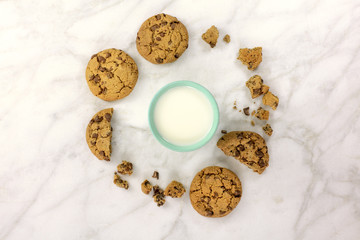 Chocolate chips cookies and glass of milk on white marble