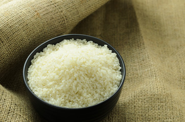 japanese rice in a black bowl on background