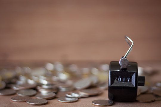 2017 number counter and blur coin on blur wood background