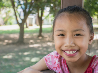 Cute Asian child sitting in a park.