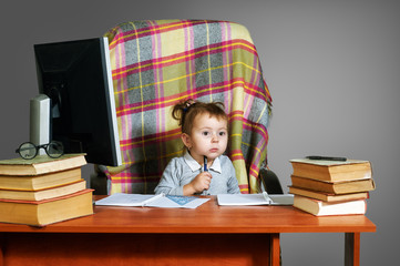 A little girl plays at the Desk of the older brother