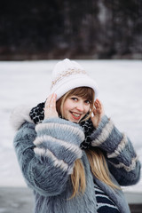 Cute pregnant girl in a fur coat outdoors