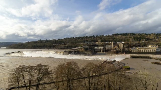 Ultra high definition 4k time lapse movie of white clouds and blue sky over fast moving high volume water Willamette Falls in Oregon City after a long heavy rainfall 4096x2304 uhd