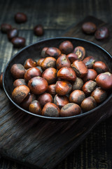 chestnuts with roasted coffee beans on wooden background. Top view selective focus.