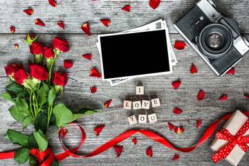 i love you inscription with blank photo frame, vintage retro camera and red roses