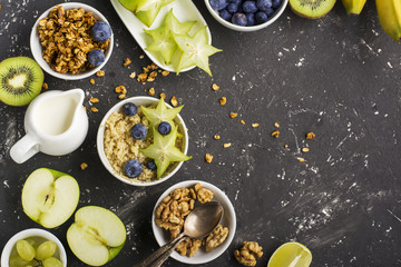Ingredients for a healthy breakfast,avocado, quinoa bowl, carambola, green apple, banana, kiwi, nuts, oatmeal, berries fruits blueberry almonds walnuts Top view. Greenery