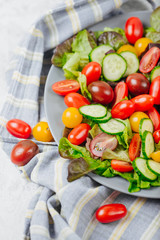 Healthy homemade salad of red and yellow cherry tomato and herbs on the table close up