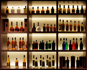 Diverses bouteilles d& 39 alcool dans un bar, rétro-éclairage, logos supprimés
