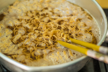 Noodles in a pan with hot food.