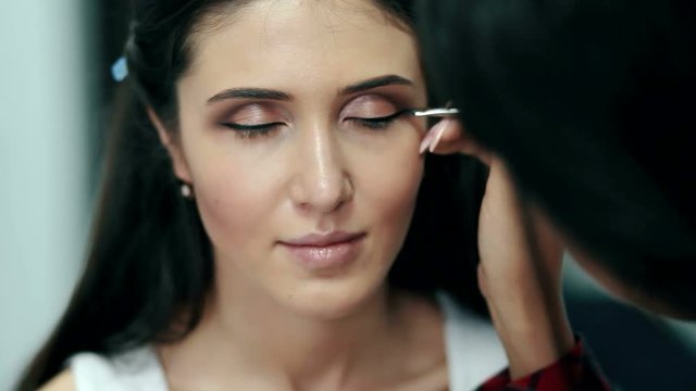 Make-up artist doing the make-up for beautiful girl