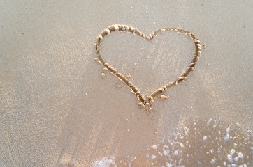 Heart drawn on a sand of beach