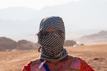 Caucasian girl in head kerchief in the desert