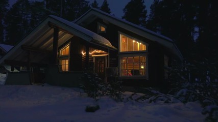 Moving by cozy wooden house in snowy forest village at winter night . - Powered by Adobe