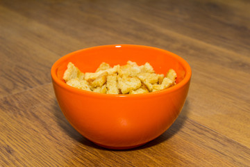 Bread rusks and croutons in orange plate.