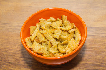 Bread rusks and croutons in orange plate.