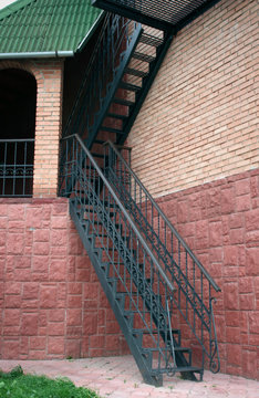 Outdoor metal ladder in traditional house on the terracotta brick wall
