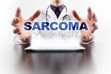 Medical doctor using tablet PC with sarcoma medical concept.