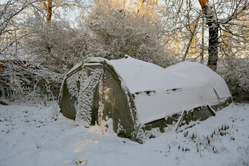 old plastic greenhouse in derelict farm and  snow