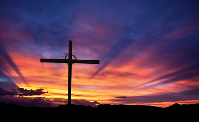 Cross silhouette on the mountain at sunset