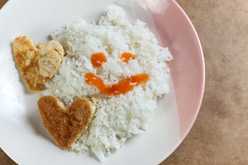 Heart shaped omelet and rice in white dish
