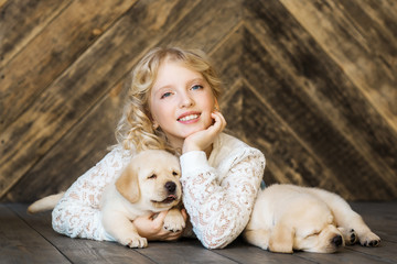 Little girl with a labrador puppies