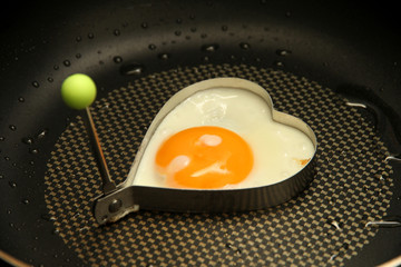 Cooking, sunny egg in heart shape pattern .