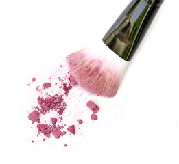 Close up of crushed blush on white background and cosmetic brush