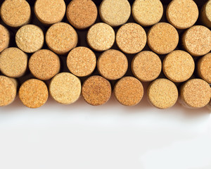 . Wine corks on light paper background for your text. Yellow beige color of cork lying in a row and copy space.