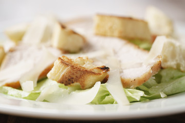 closeup shot of fresh simple caesar salad with chicken, shallow depth of field