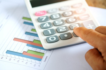 Hand using calculator on graph.