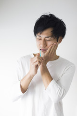 Fototapeta na wymiar 虫歯を気にする歯磨き中の男性