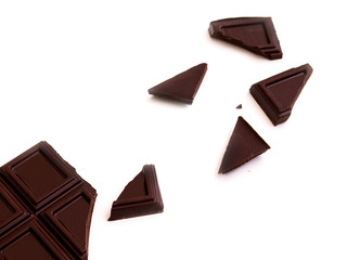 broken bar of dark chocolate isolated on white background