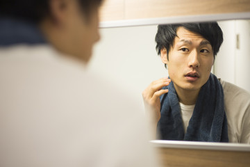 肌をチェックする日本人男性