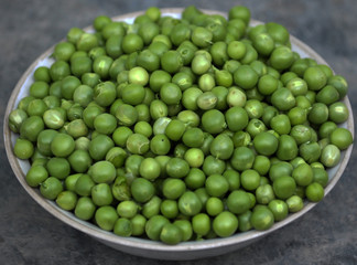 Nuts young pea seeds, green, peeled embankment in white plate