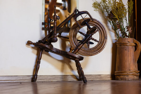 Traditional devices, vintage tailoring equipment concept. Old fashioned wooden distaff, spindle, spinning wheel