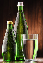 Composition with glass and bottles of mineral water