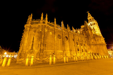 Fototapeta na wymiar The spectacular and illuminated Cathedral of Seville and Giralda by night, the world's largest Gothic Cathedral and the third religious building to size, Andalucia, Spain