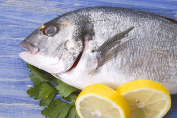 bream with parsley and lemon on bottom of wood blue