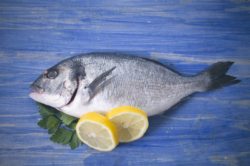 bream with parsley and lemon on bottom of wood blue
