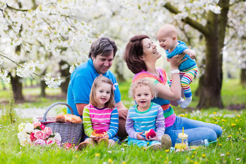 Fototapeta premium Family with children enjoying picnic in spring park