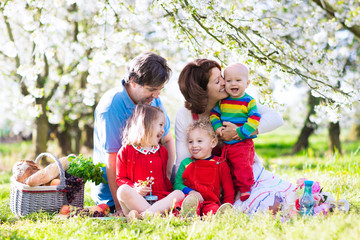 Fototapeta premium Family with kids on picnic in spring garden