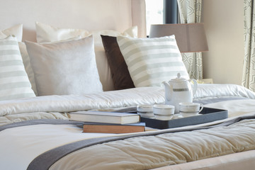 elegant tea cup set on black tray and books in modern bedroom interior
