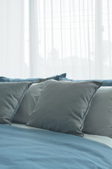 Gray pillows on bed with bed runner in blue color